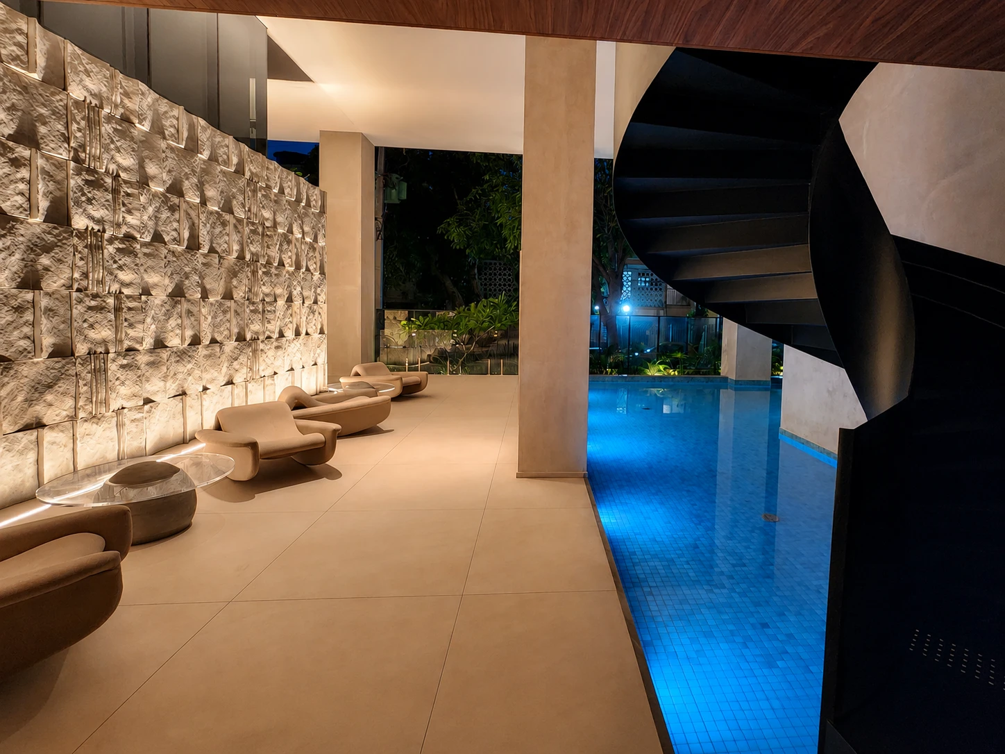 Hall do Afonso 1095 com parede em pedra, piscina e escada escultural